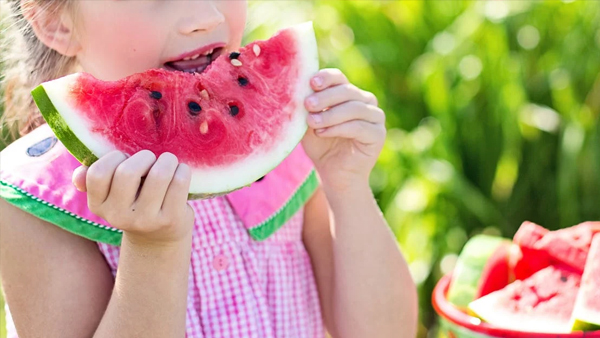 Ein Kind beisst in eine Wassermelone